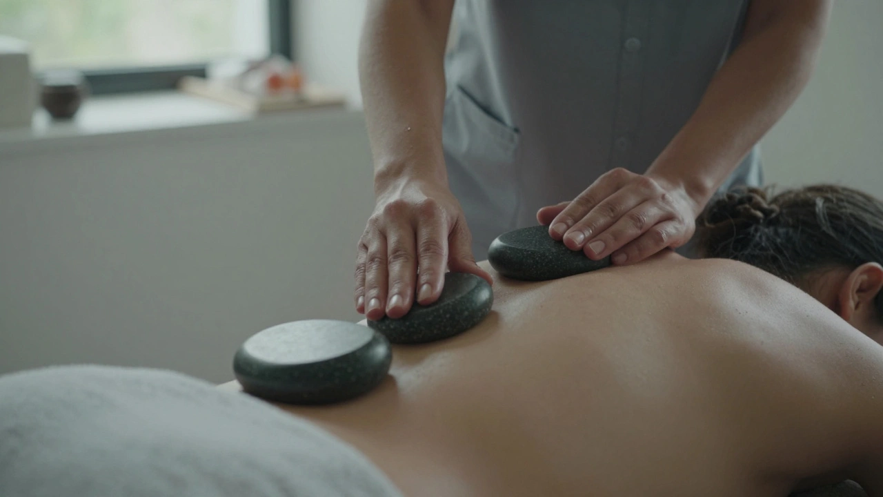 A therapist using heated stones to massage a client's lower back, with cool marble stones resting on their shoulders.